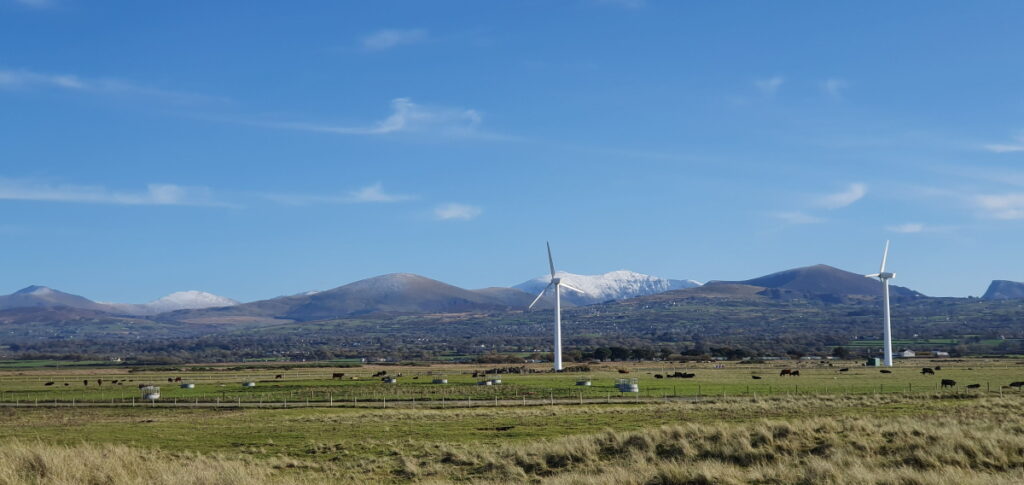 Wind turbines with snowy Snowdonia mountains in background